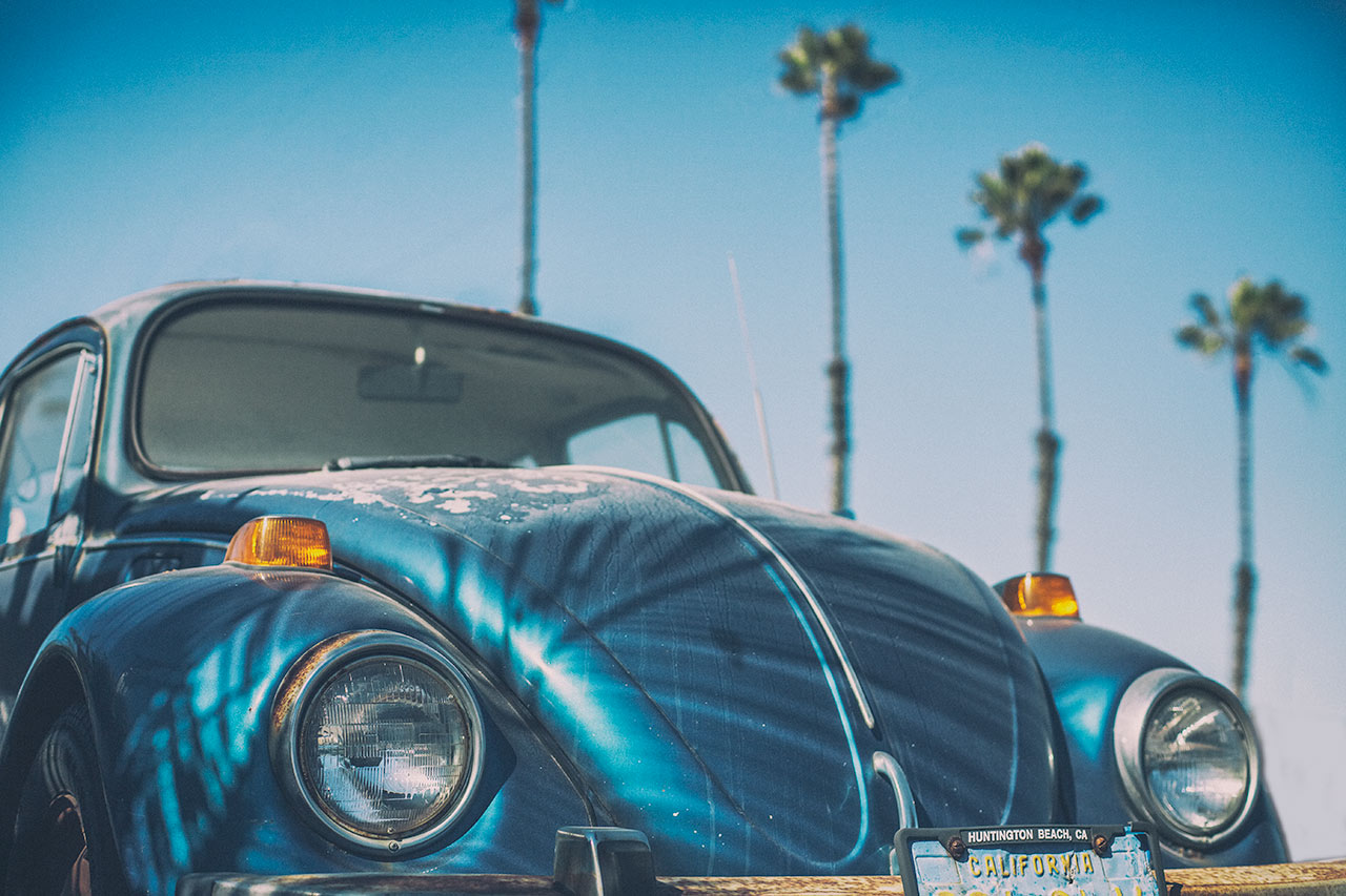 Vintage Volkswagen Beetle surrounded by palm trees in Newport Beach California