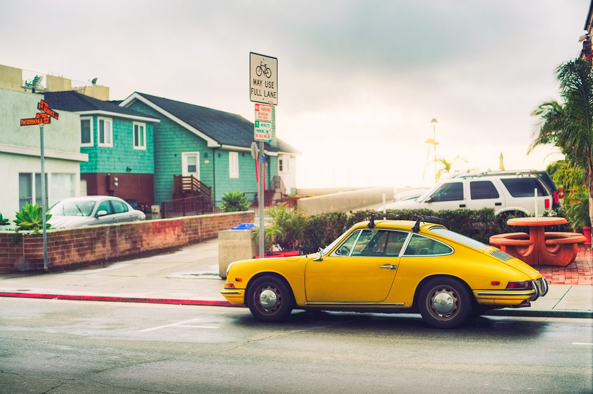 Classic yellow Porsche next to the Pacific Ocean in Hermosa Beach California